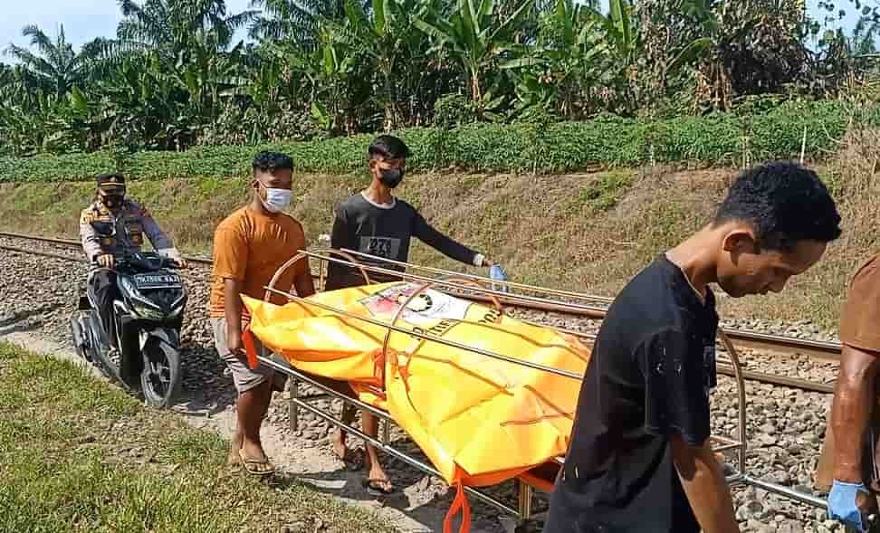 Warga bersama Polsek Lima Puluh menggotong mayat OTK (Senin,27/12/2021) (kedannews.com/Sholeh Pelka)