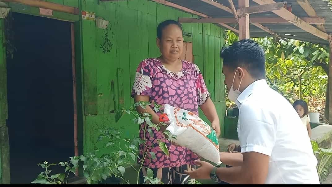 Koordinator Kadin Batu Bara berbagi, Burhan Saleh saat memberikan bantuan kepada warga Desa Tanah Merah, Air Putih. Kamis (27/01/2022). (kedannews.com/Foto: Sholeh Pelka)