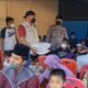AKP Rusdi bersama KSJ saat memberikan santunan anak yatim dan dhuafa di Mapolsek Lima Puluh. Jumat (28/01/2021) . (Foto/Humas)