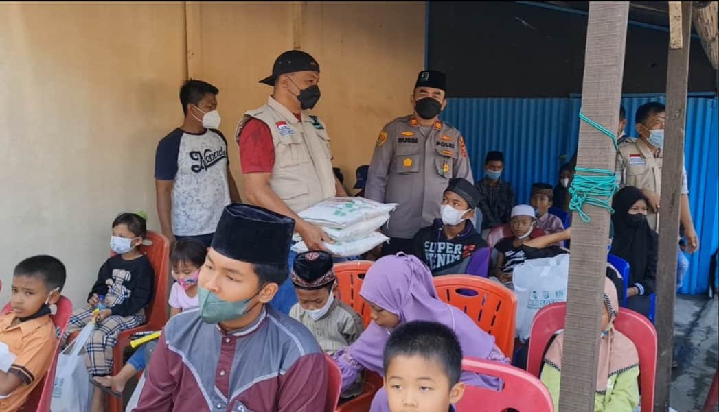 AKP Rusdi bersama KSJ saat memberikan santunan anak yatim dan dhuafa di Mapolsek Lima Puluh. Jumat (28/01/2021) . (Foto/Humas)