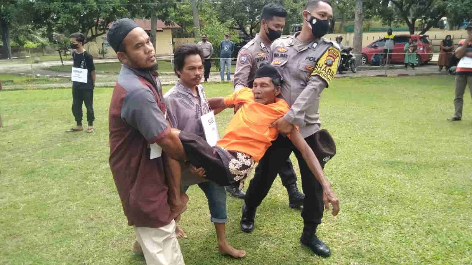 Tersangka Tok Dalang terkulai lemas pada adegan kedua dari 15 adegan rekonstruksi di Mapolsek Indrapura. Jumat (11/02/2022). (Foto/Humas).