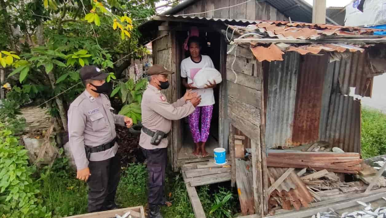 Personil Polsek, bersama Babinkamtibmas saat memberikan bantuan sembako di rumah penduduk. Jum’at (25/02/2022). (Foto/Humas).