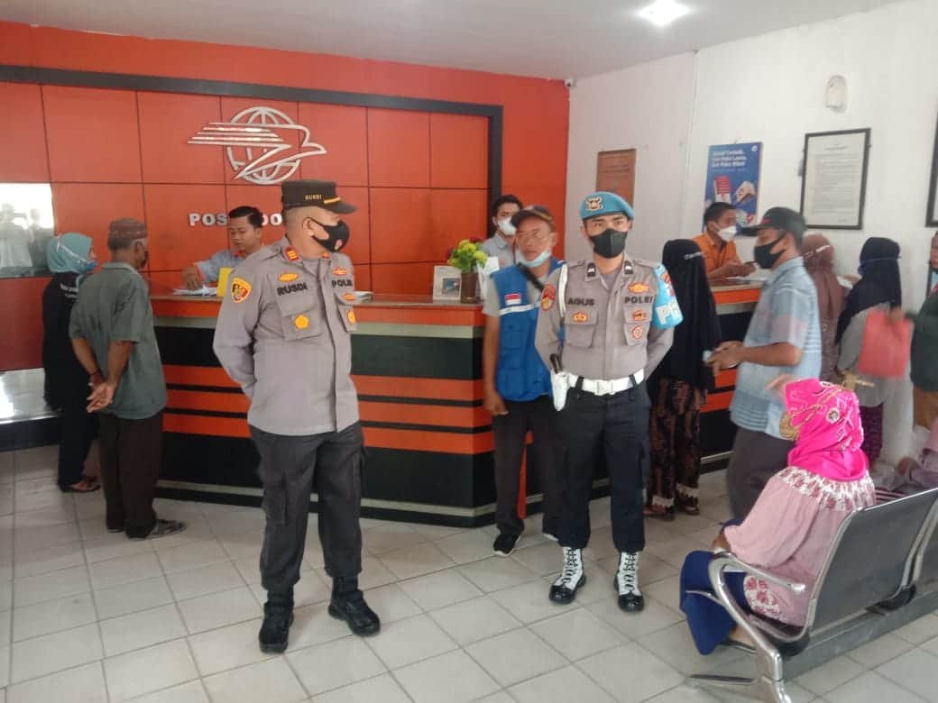 Kapolsek Lima Puluh Polres Batu Bara AKP Rusdi bersama personil melakukan monitoring penyaluran BPNT di Kantor Pos Lima Puluh, Senin (28/2/2022). (Foto/Humas).