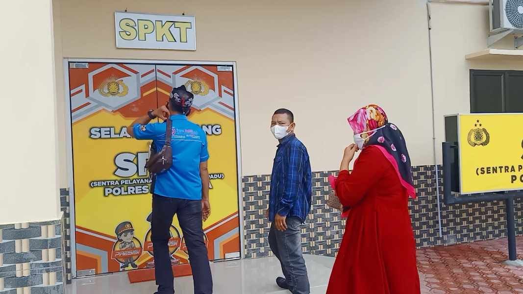N bersama tetua kampung melaporkan suaminya ke SPKT Polres Batu Bara.(Foto: Sholeh Pelka).