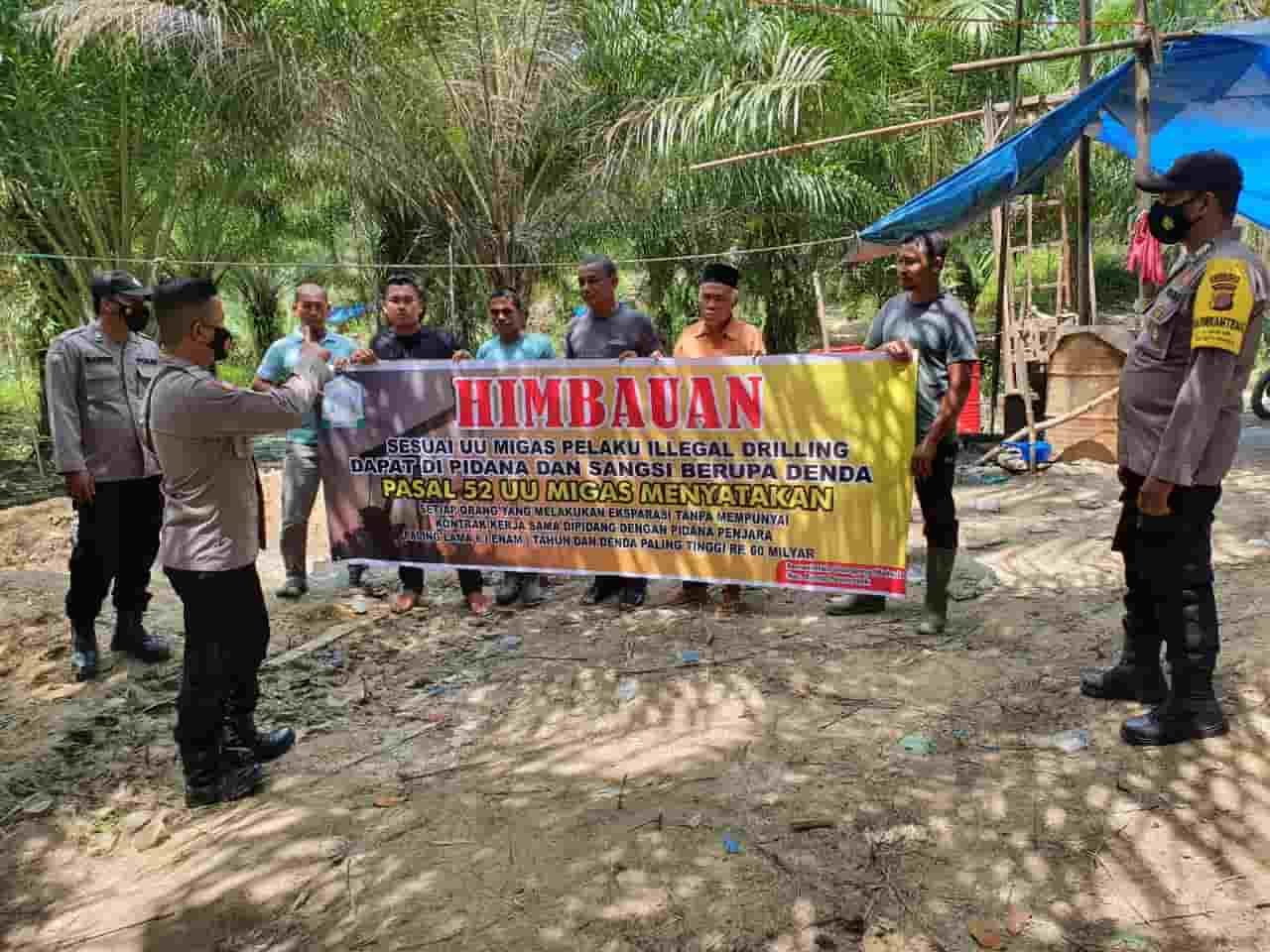 Personel Kepolisian saat bentang spanduk himbauan. , Sabtu (12/03/2022). (Foto/Humas).