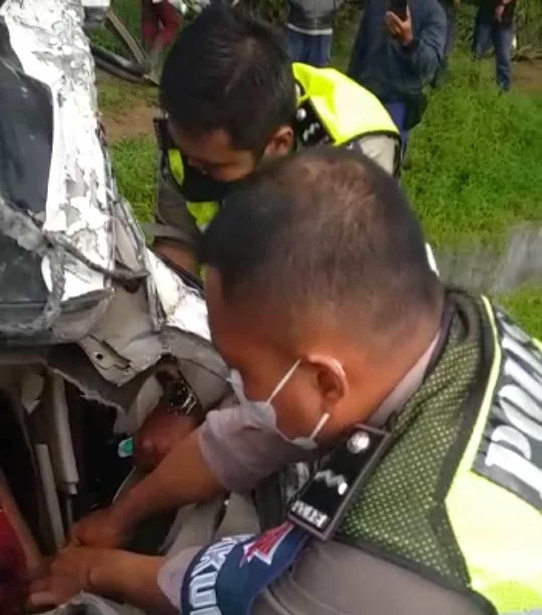 Petugas Satlantas Polres Batu Bara, saat berusaha mengeluarkan korban tewas yang terjepit di TKP. Rabu (23/03/2022). (Foto/Humas).