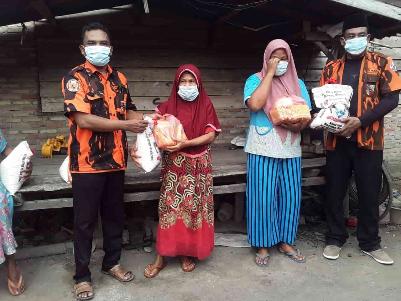 Ketua MPC PP Labuhanbatu bersama anggota Serahkan Paket Sembako ke Kaum Dhuafa. (Foto: Samuel Tampubolon).
