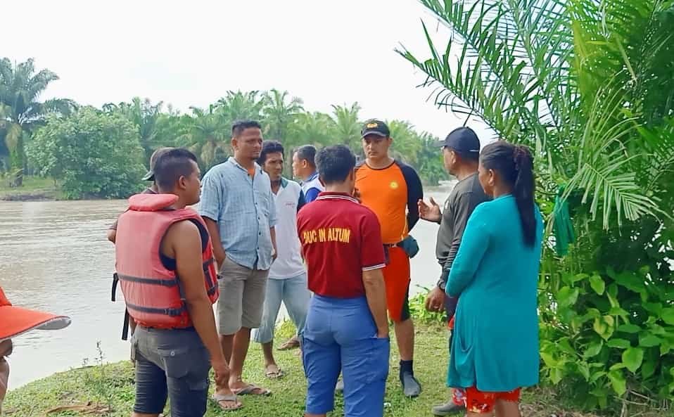 Kepala Desa Tanjung Muda, Khazeli bersama dengan tim Basarnas di pinggiran Sungai Dalu - Dalu. (Foto/Tim).