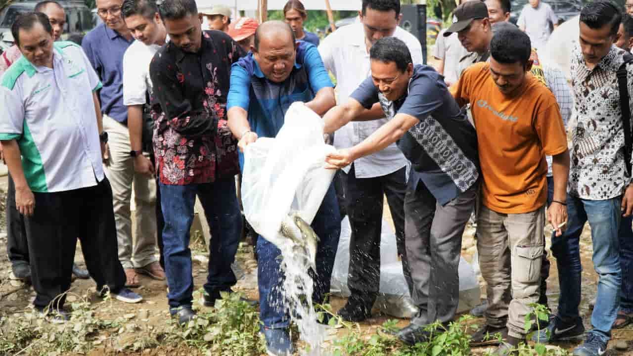 Bang Ondim bersama warga saat penaburan bibit ikan jurung berjumlah 300 ekor dikolam dekat rumah aspirasi. (Foto/Humas).