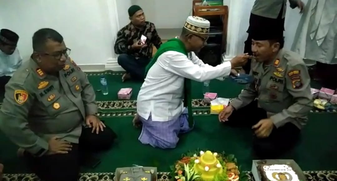 Kapolsek Indrapura, AKP Sandi dan Kapolsek Medang Deras, AKP Mhd Syafii, saat disulangi nasi tumpeng oleh Ustazd Tahan Siregar