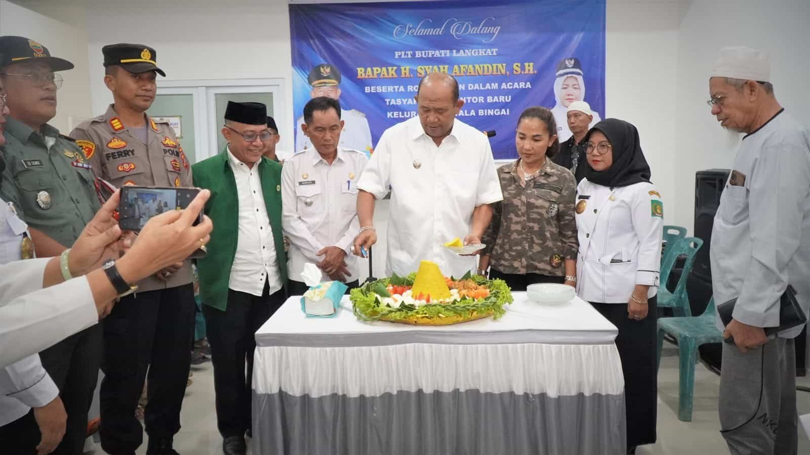 Plt Bupati Langkat Syah Afandin saat memotong nasi tumpeng saat peresmian kantor baru, Rabu (132023). (Foto Ist).