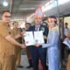 Keterangan foto : Camat Sitinjo Tony Simon Malau (berkacamata hitam) saat menyerahkan akta pernikahan kepada pengantin baru marga Tampubolon di desa Sitinjo, Selasa (16/5/2023). (foto : Sondang).