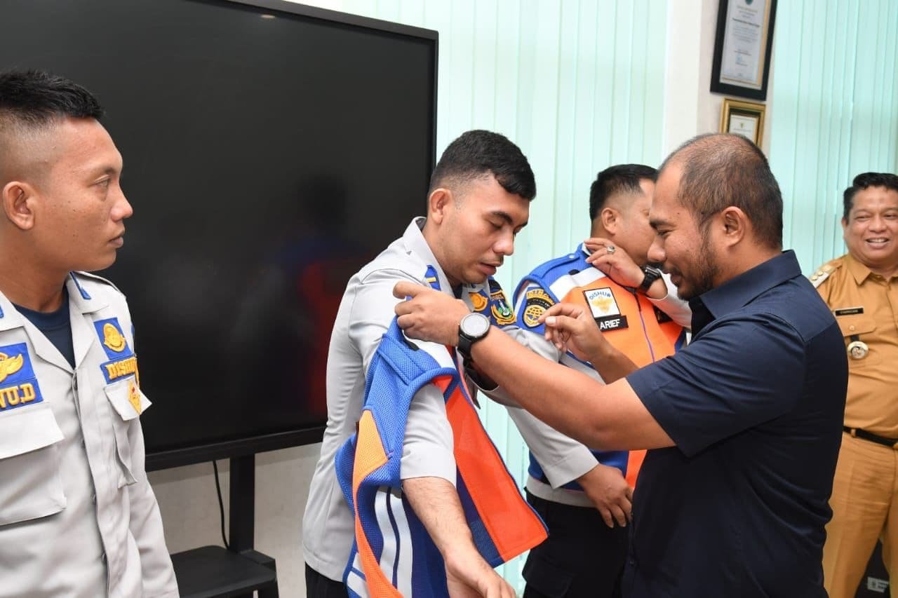 Foto: Corporate Secretary INALUM Mahyaruddin Ende saat memakaikan Rompi kepada seseorang petugas Dishub Kota Tebing, di kantor Walikota Tebing Tinggi, Selasa (5/9/2023). (kedannews.com/istimewa).