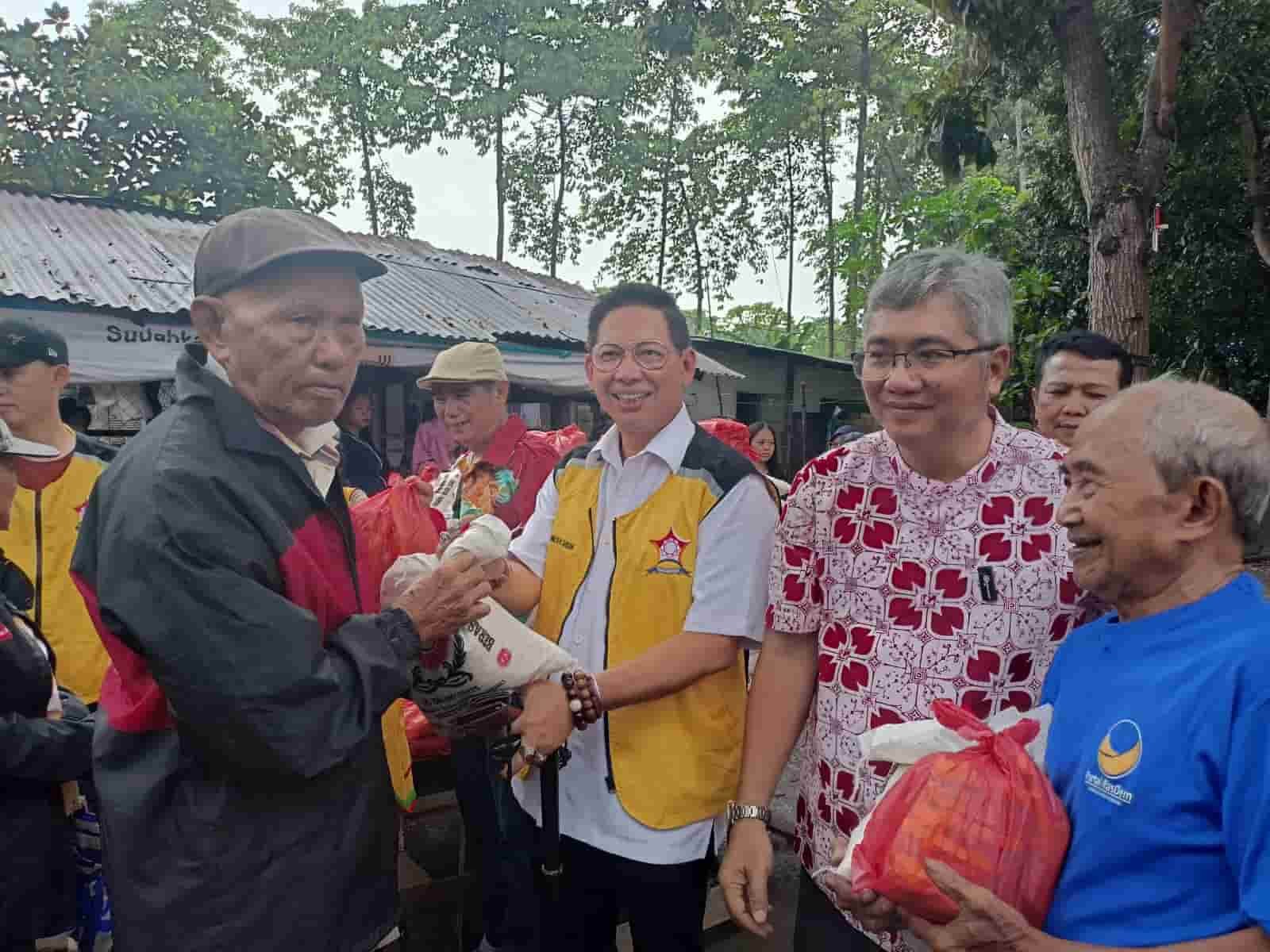 Foto: Anggota DPRD Medan Wong Chun Sen (rompi kuning berkaca mata) saat bagikan sembako kepada Warga Prasejahtera di Kota Bangun Kecamatan Medan Deli Kota Medan, Minggu (19/11/2023). (kedannews.com/ist).