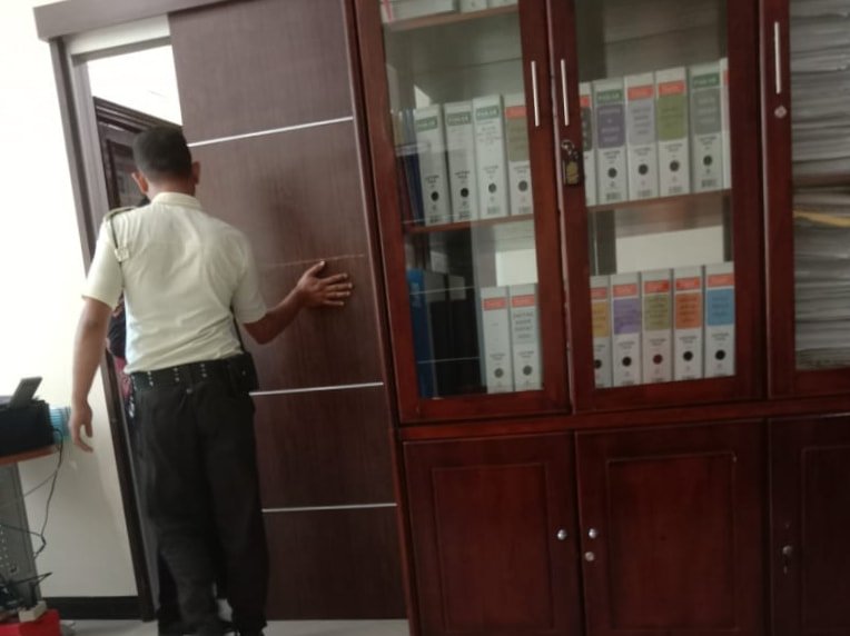 Salah seorang Security DPRD Medan saat menutup pintu ruangan Rapat Dengar Pendapat (RDP) Komisi IV DPRD Medan dengan Dinas Sumber Daya Air Bina Marga dan Bina Konstruksi (SDABMBK) Kota Medan digelar tertutup, Selasa (23/04/2024). (kedannews.com/ist).