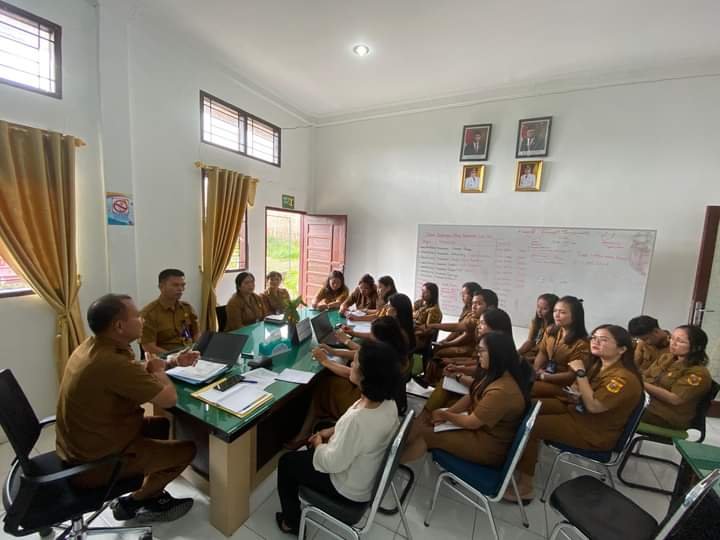 Kepala Dinas Dukcapil kabupaten Dairi Deddy Situmorang (membelakangi kamera) memimpin rapat dengan seluruh petugas loket layanan di ruang kerjanya, Rabu (8/5/2024). (kedannews.com/ Sondang Silalahi).