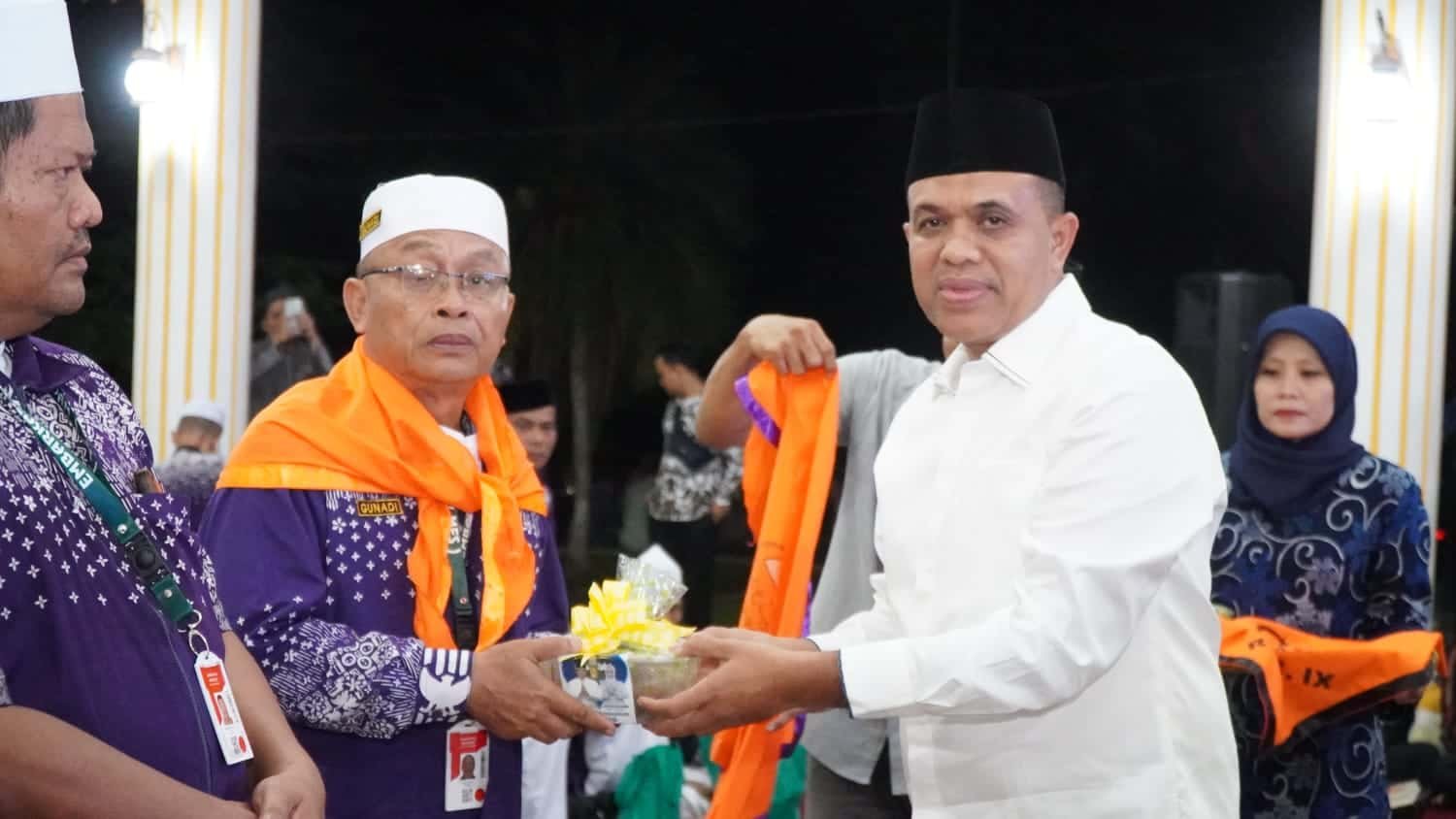 Pj Bupati Langkat H. M. Faisal Hasrimy, AP., M.AP, saat memberikan bingkisan kepada Jemaah Calon Haji Kloter 7 Kabupaten Langkat yang dilaksanakan Ba'da Shubuh Minggu, (19/5/2024). (kedannews.com/Aris).