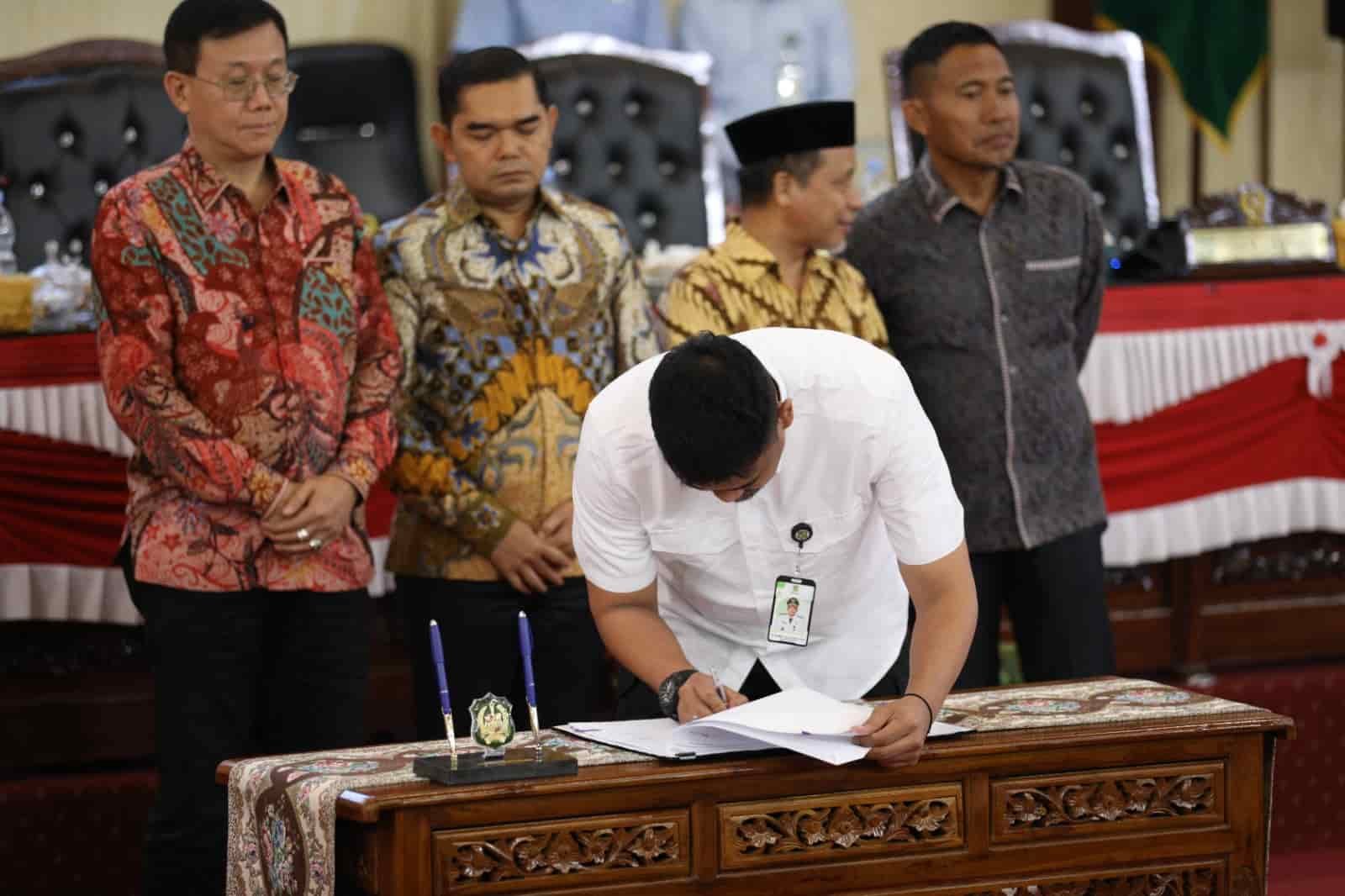 Wali Kota Medan, Bobby Nst saat tandatangani Konsep Keputusan dan Persetujuan pada Rapat Paripurna tentang Penyampaian Laporan Badan Anggaran, Pendapat Fraksi-fraksi DPRD Kota Medan dan Penandatanganan/Pengambilan Keputusan DPRD Kota Medan Sekaligus Persetujuan Bersama atas Ranperda Kota Medan tentang Pertanggungjawaban Pelaksanaan APBD Kota Medan Tahun 2023 yang berlangsung di Ruang Rapat Paripurna DPRD Medan, Selasa (25/06/2024) siang (kedannews.com/ist).