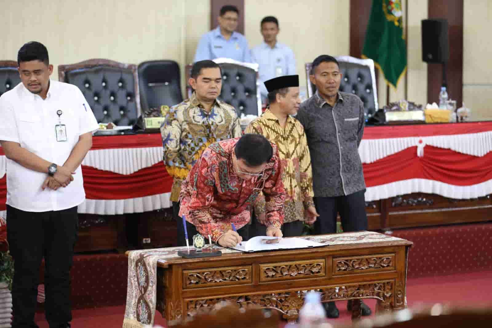 Ketua DPRD Medan, Hasyim saat tandatangani Konsep Keputusan dan Persetujuan pada Rapat Paripurna tentang Penyampaian Laporan Badan Anggaran, Pendapat Fraksi-fraksi DPRD Kota Medan dan Penandatanganan/Pengambilan Keputusan DPRD Kota Medan Sekaligus Persetujuan Bersama atas Ranperda Kota Medan tentang Pertanggungjawaban Pelaksanaan APBD Kota Medan Tahun 2023 yang berlangsung di Ruang Rapat Paripurna DPRD Medan, Selasa (25/06/2024) siang (kedannews.com/ist).
