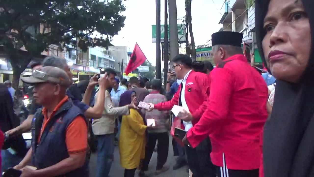 Ketua PAC PDI Perjuangan Medan Area, Bobby C. Halim, S.H., M.H., CPM, bersama pengurus PAC dan ranting membagikan takjil kepada pengendara dan pejalan kaki di depan Hotel TravelBiz, Jalan Sutrisno, Medan, Senin (24/3/2025). (Foto: Aris/kedannews.com).