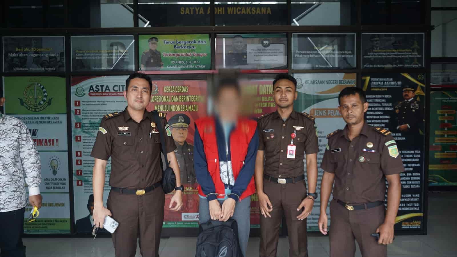 Tersangka RSR mengenakan rompi tahanan dan borgol saat digiring oleh petugas Kejaksaan Negeri (Kejari) Belawan menuju mobil tahanan, Senin (17/03/2025). RSR resmi ditahan terkait dugaan tindak pidana korupsi dalam proyek pembangunan Gedung KDP Balai Keselamatan dan Kesehatan Kerja (K3) Medan Tahun Anggaran 2022 yang merugikan negara Rp 234.981.554. (Foto: ist./kedannews.com)